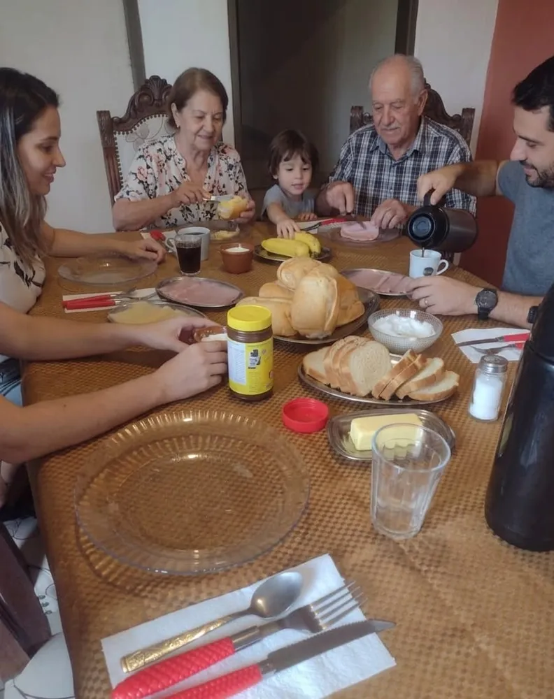 Família reunida à mesa do café da manhã na hospedaria